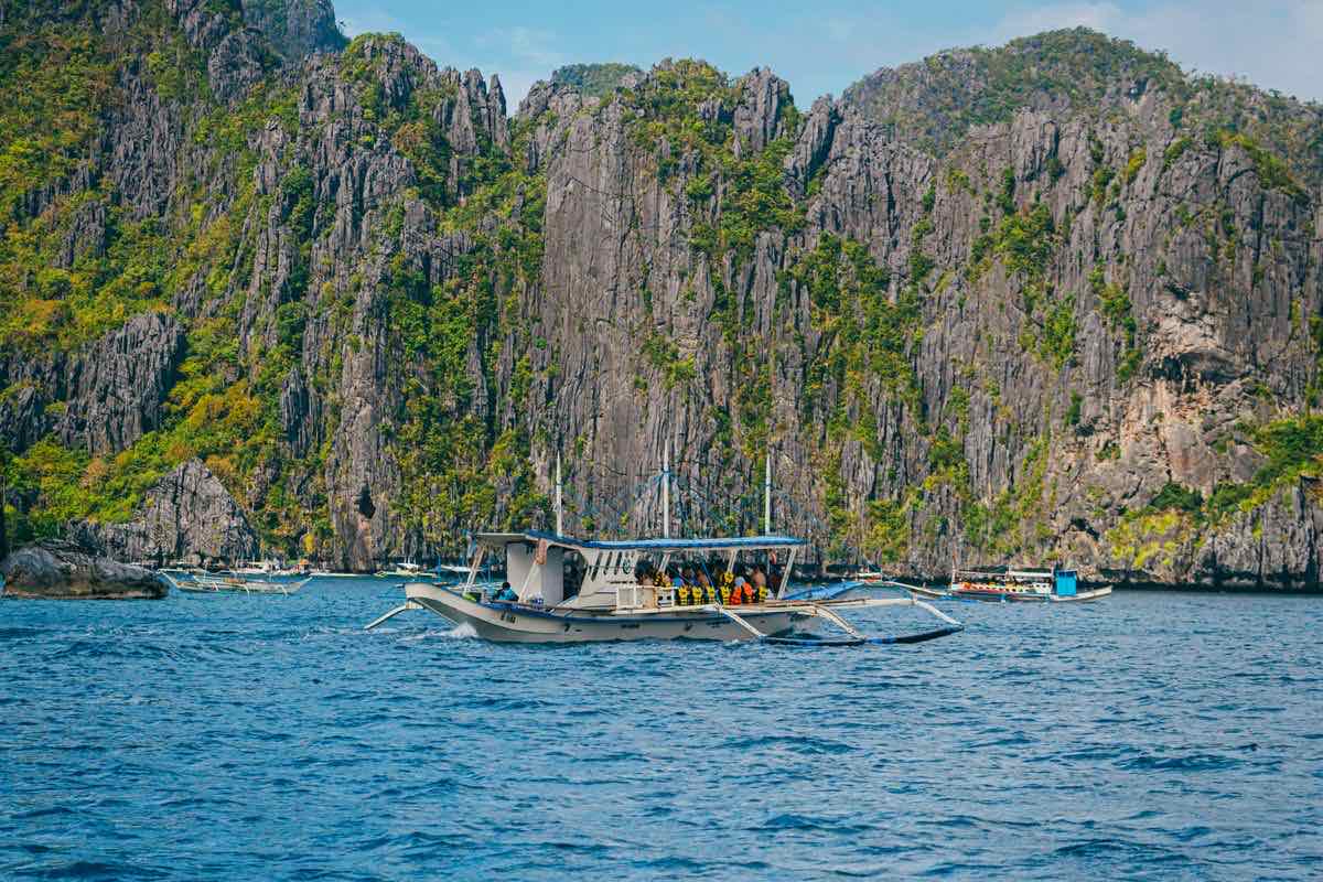 Une bangka d'island hopping devant les falaises d'El Nido. Photo : Nothing Ahead / Pexels