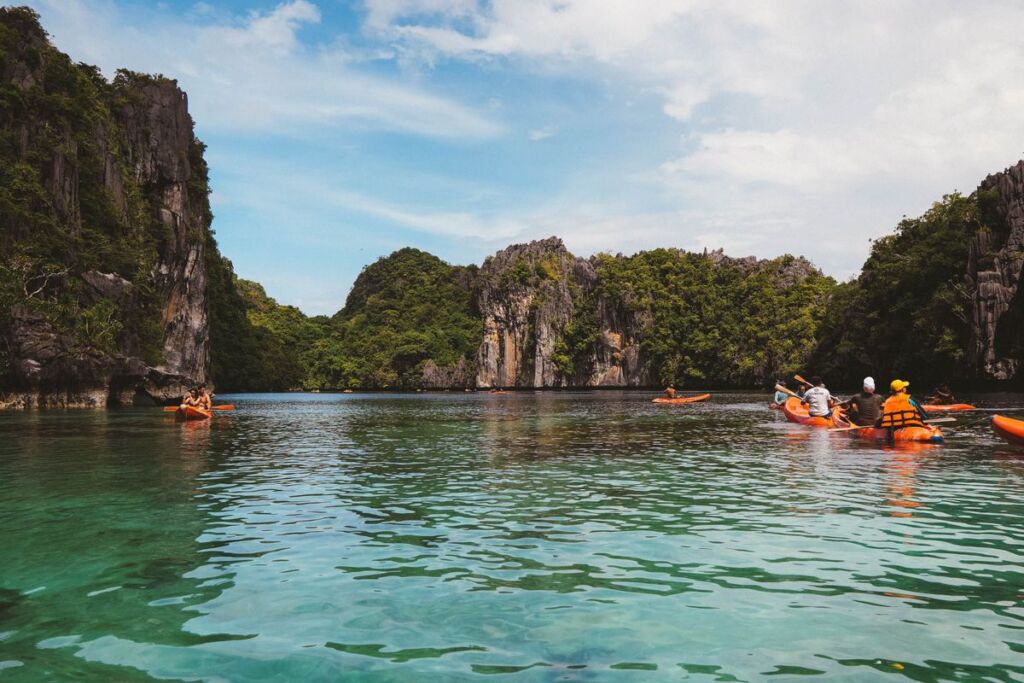 Kayaks entrant dans un lagon d'El Nido entre les falaises calcaires