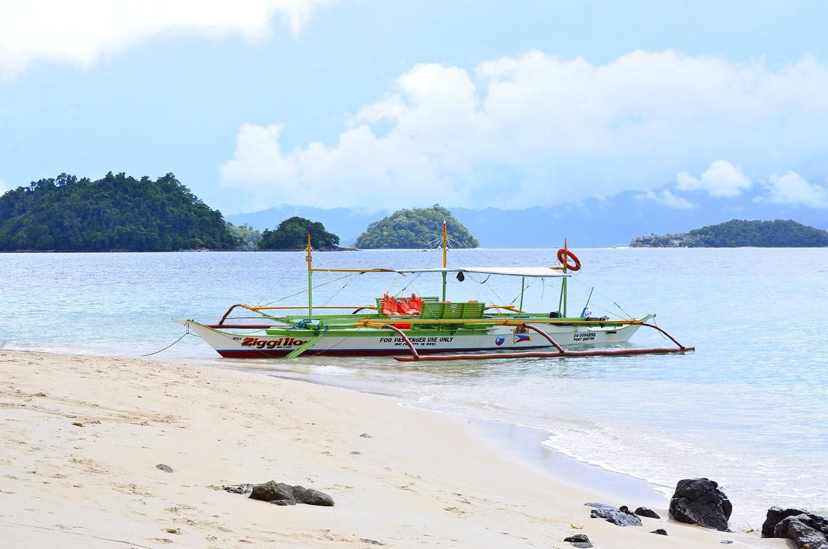 Bangka immatriculée à Port Barton amarrée sur un banc de sable blanc pendant une journée d'island hopping, Palawan