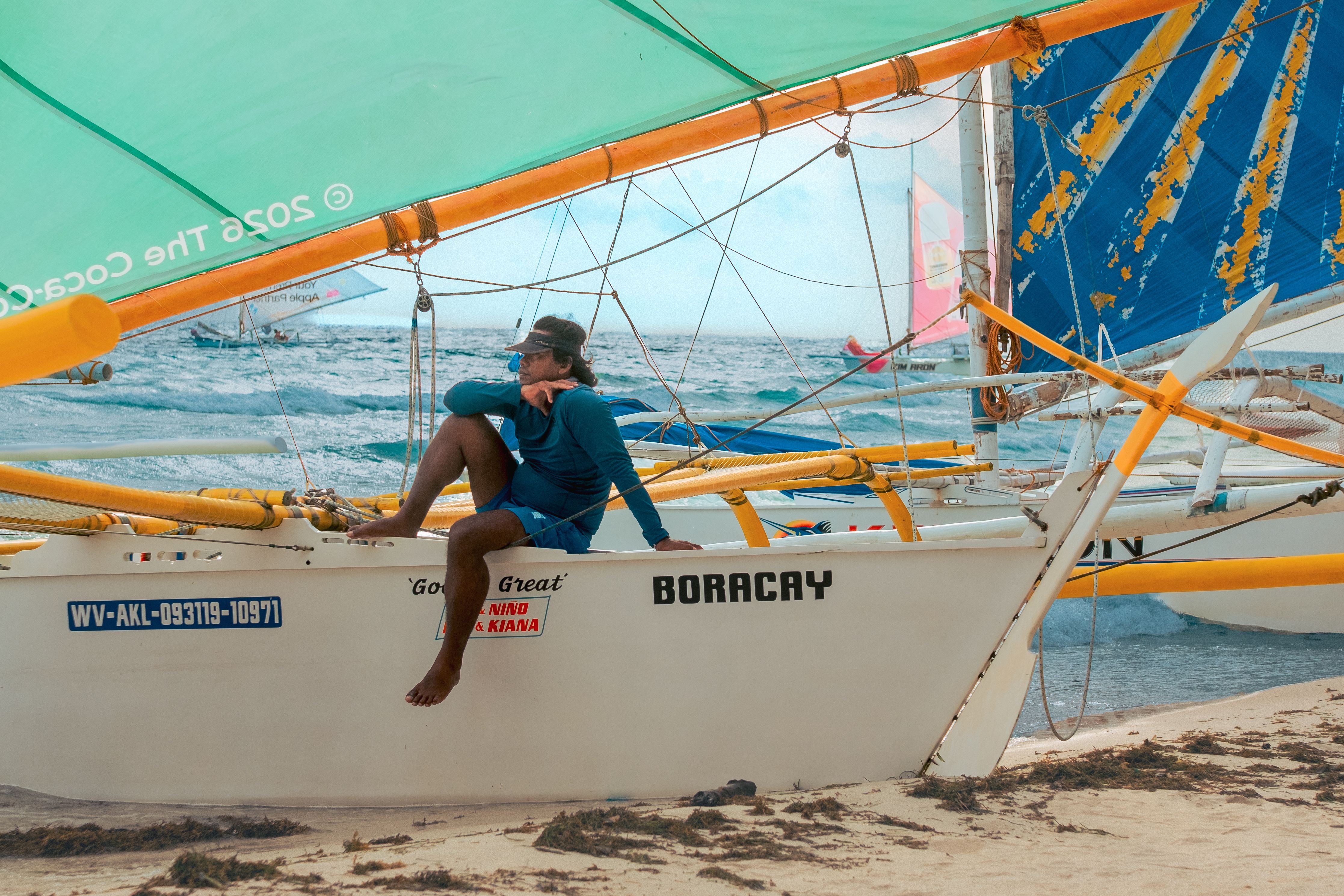Voilier paraw à balanciers marqué Boracay sur la plage de sable blanc