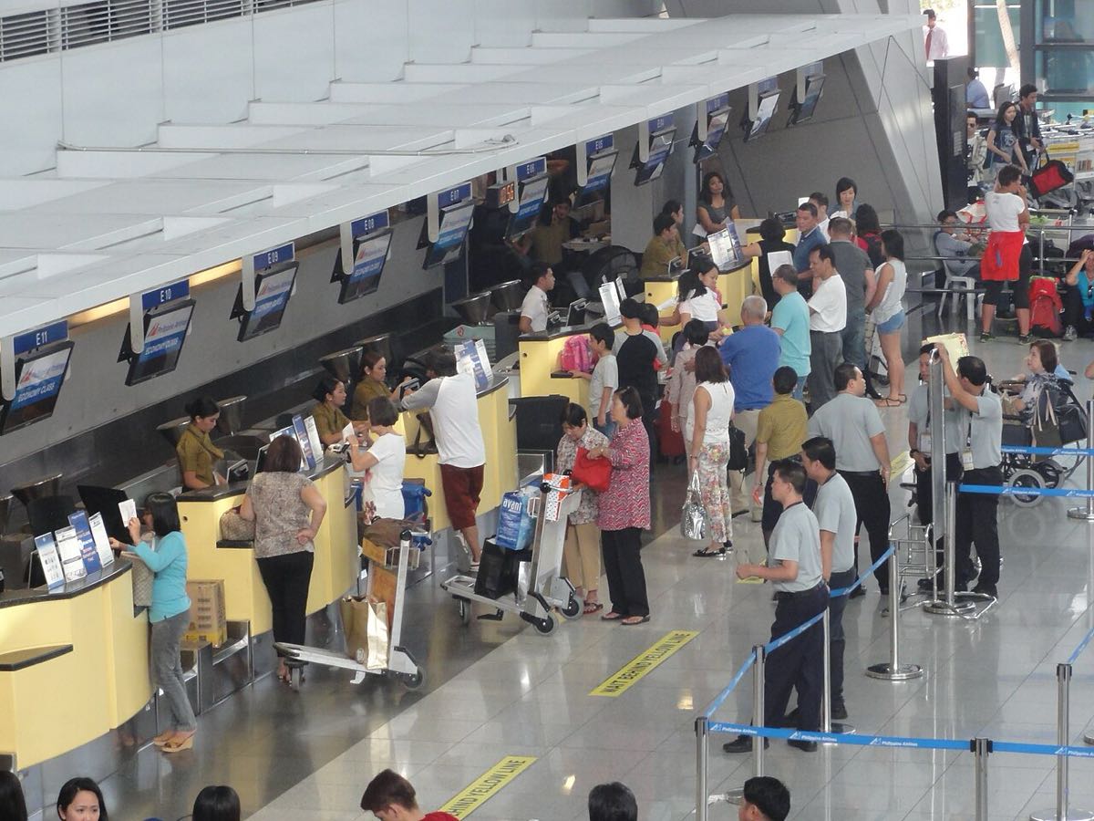 Comptoirs d'enregistrement du terminal 3 de l'aéroport NAIA de Manille, passagers en file